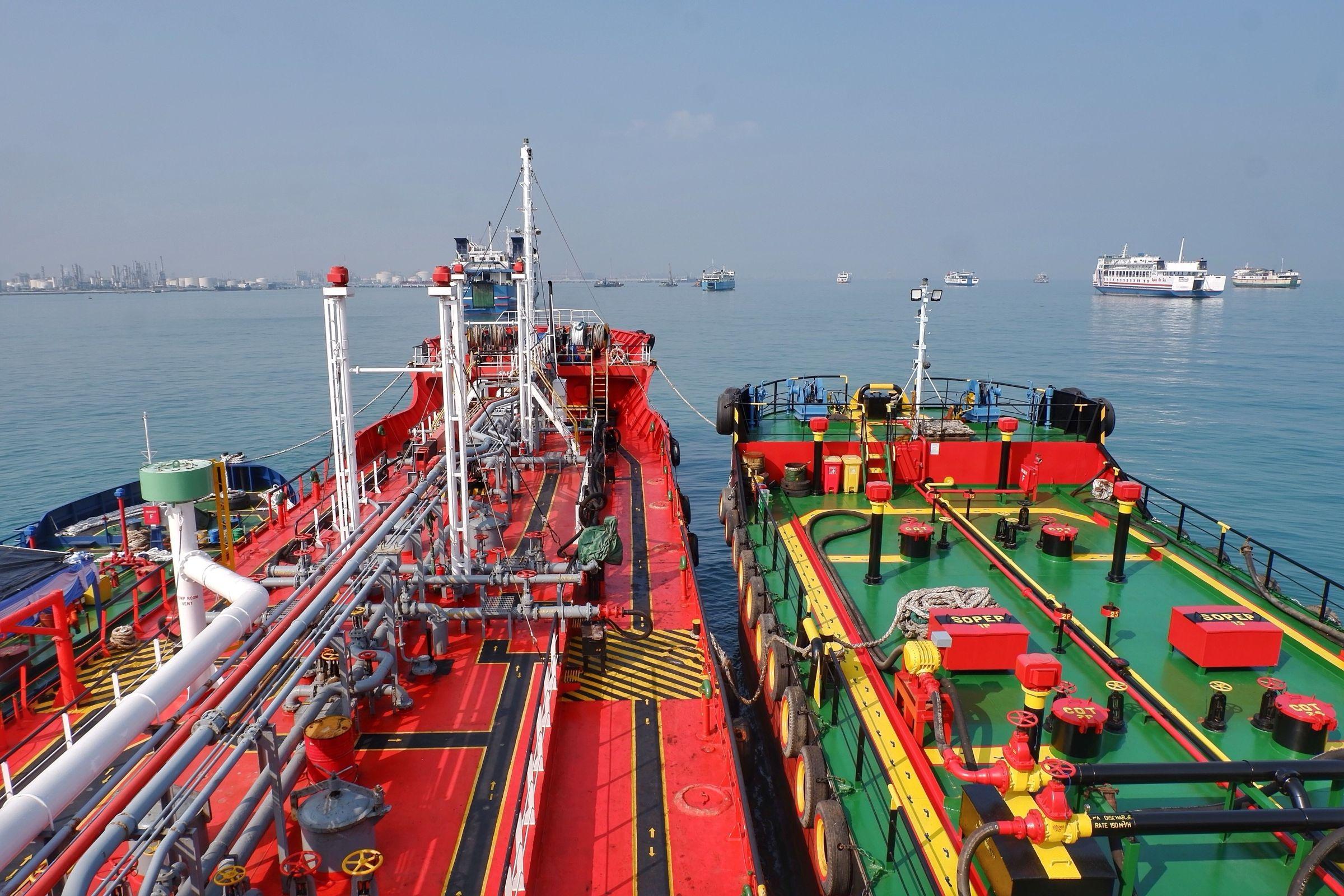 Bunker barge alongside a merchant vessel during fuel delivery